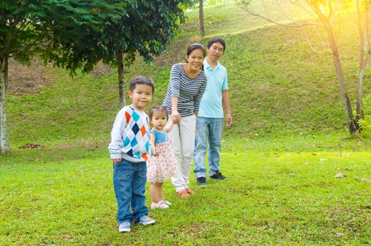 Outdoor portrait of happy asian family