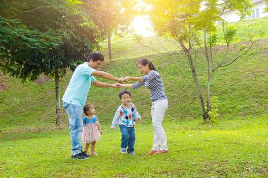 Asian family outdoor quality time enjoyment, asian people playing during beautiful sunset.