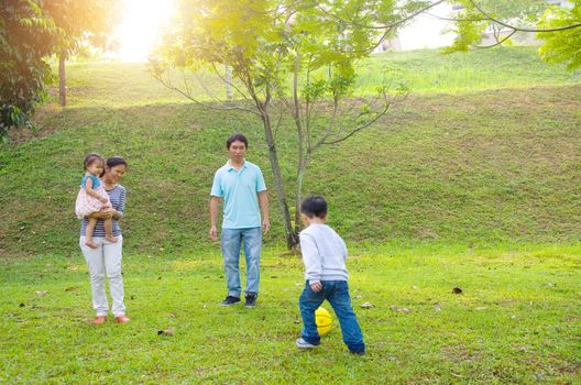 Asian family outdoor quality time enjoyment, asian people playing during beautiful sunset.