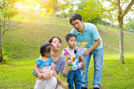Asian family blowing bubbles outdoor