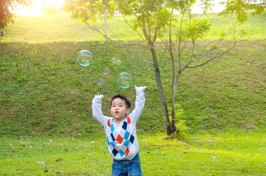 Asian boy playing bubbles outdoor