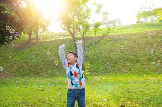 Asian boy playing bubbles outdoor