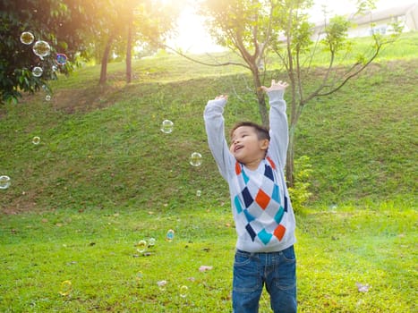 Asian boy playing bubbles outdoor