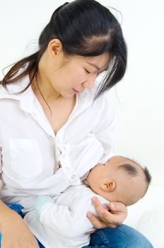 Asian mother breastfeeding her baby boy