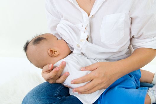 Asian mother breastfeeding her baby boy