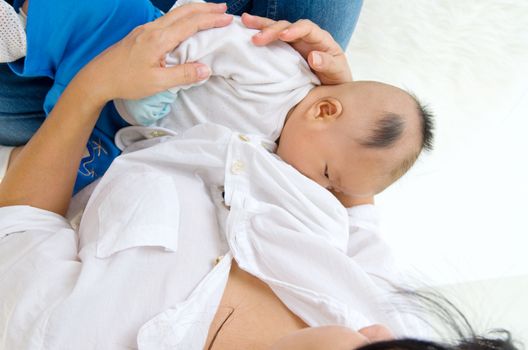 Asian mother breastfeeding her baby boy