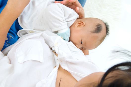 Asian mother breastfeeding her baby boy