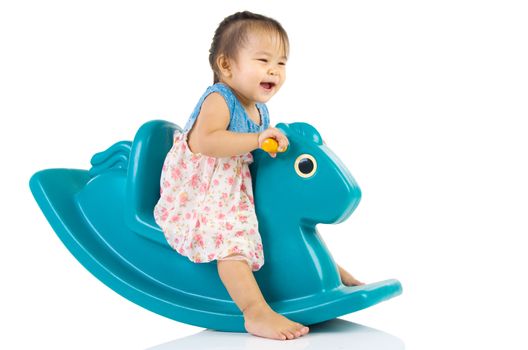 smiling asian girl playing with Toy horse