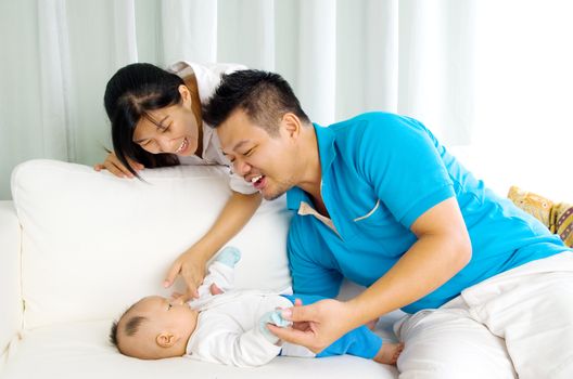 Asian family playing with their baby