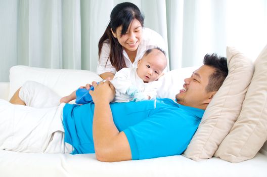 Asian family playing with their baby