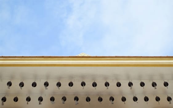 Row of bell on roof of temple Golden Mountain in Bangkok Thailand with blue sky and cloud.