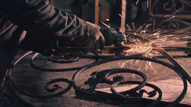 Close up of man's hands smoothing metal grate