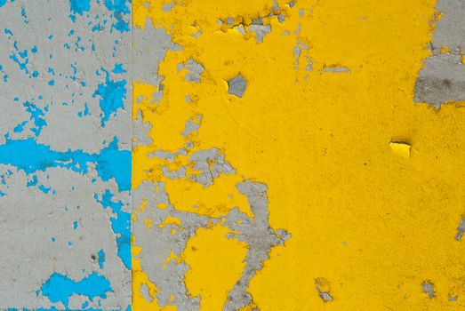 fragment of an iron surface is covered with blue and yellow color paint, which has long been under the influence of different climatic conditions