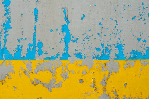 fragment of an iron surface is covered with blue and yellow color paint, which has long been under the influence of different climatic conditions