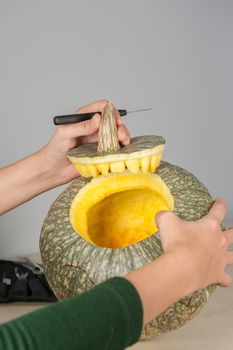 woman hands making pumpkin for halloween holidays.