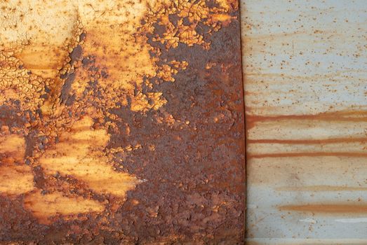 rusty iron surface covered with old chipped yellow color paint, which has long been influenced by different climatic conditions