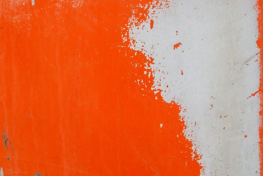 fragment of an iron surface is covered with orange and grey color paint, which has long been under the influence of different climatic conditions