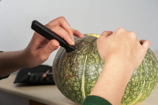 woman hands making pumpkin for halloween holidays.