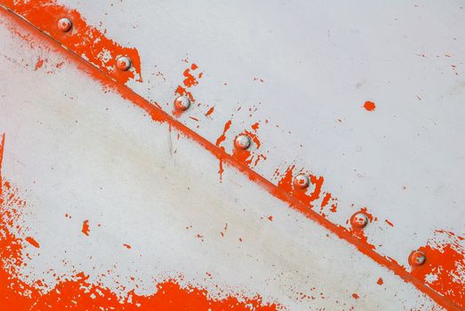 fragment of an iron surface is covered with orange and grey color paint, which has long been under the influence of different climatic conditions