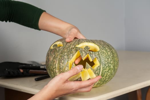 woman hands making pumpkin for halloween holidays.