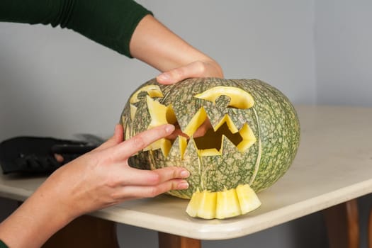 woman hands making pumpkin for halloween holidays.