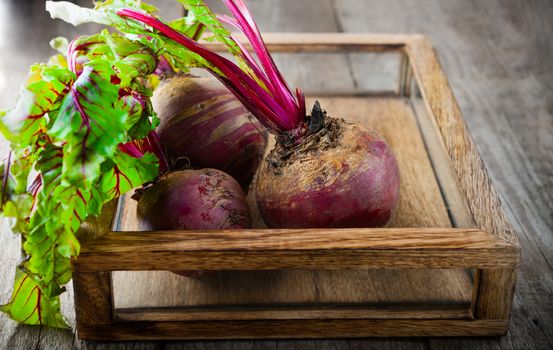 Fresh organic beets on a wood table.
