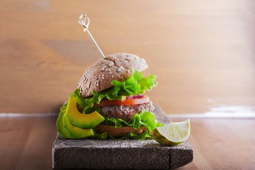 Delicious homemade burger on rustic wooden desk 