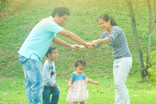 Asian family outdoor quality time enjoyment, asian people playing during beautiful sunset.