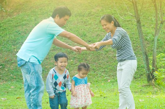 Asian family outdoor quality time enjoyment, asian people playing during beautiful sunset.