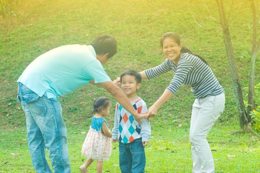 Asian family outdoor quality time enjoyment, asian people playing during beautiful sunset.