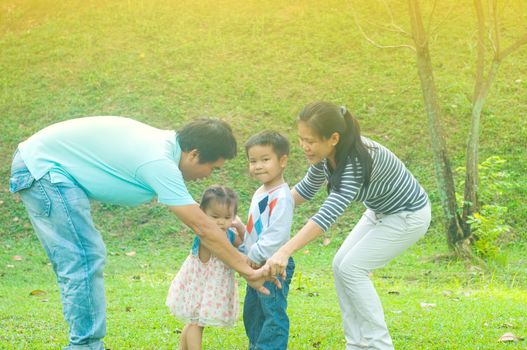 Asian family outdoor quality time enjoyment, asian people playing during beautiful sunset.