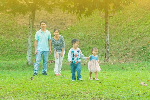 Asian family outdoor quality time enjoyment, asian people playing during beautiful sunset.