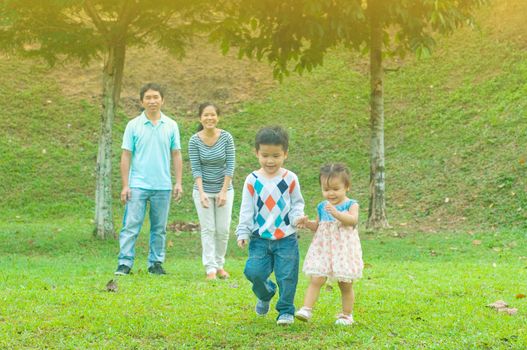 Asian family outdoor quality time enjoyment, asian people playing during beautiful sunset.