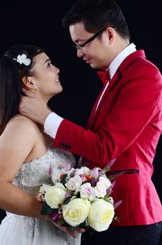 Attractive Bride and Groom at Wedding with flower over black background