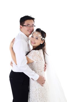 Portrait of young elegant enamoured just married groom and bride embracing at Wedding on white background