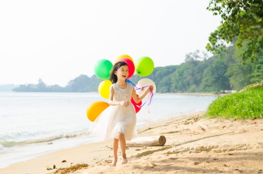 happy asian girl playing on the beach