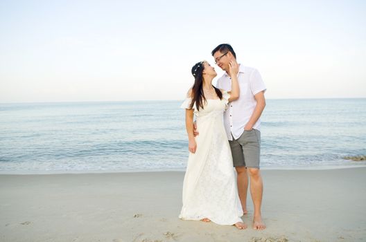 Asian bride and groom on a tropical beach. Wedding and honeymoon concept.