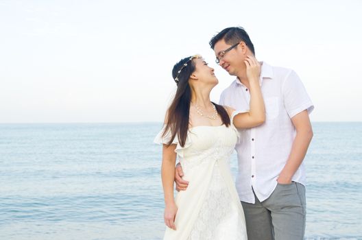 Asian bride and groom on a tropical beach. Wedding and honeymoon concept.