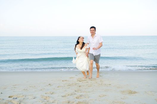 Asian bride and groom on a tropical beach. Wedding and honeymoon concept.