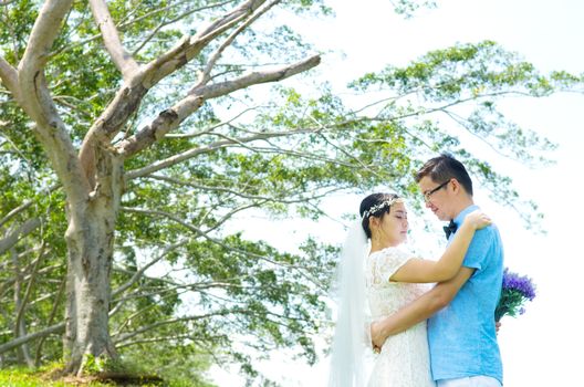 The asian couple embracing in the park