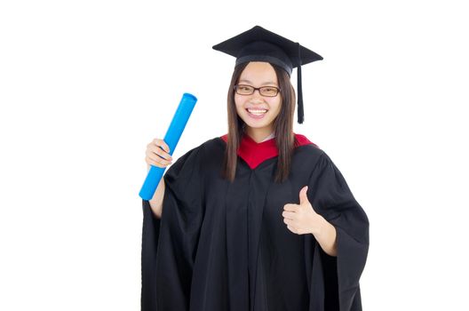 Happy university student in graduation gown and cap. Portrait of east Asian female model standing on plain background.