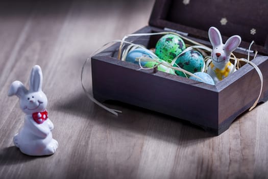 Easter bunny with colorful eggs in a box 