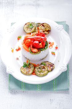 Rice timbale with fried zucchini, peppers, carrots