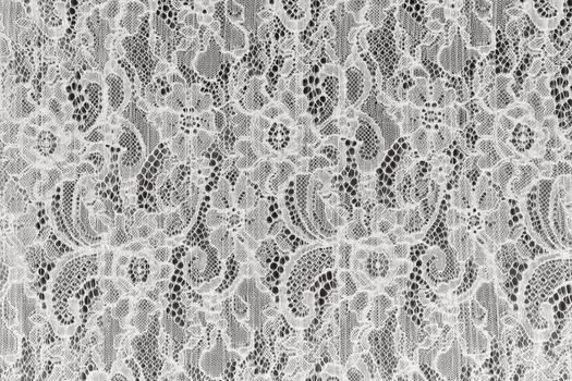 White openwork lace background texture. White guipure fabric with ornament. delicate lace with floral pattern