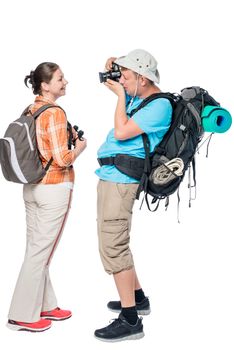 Man tourist with a backpack photographing his girlfriend isolated