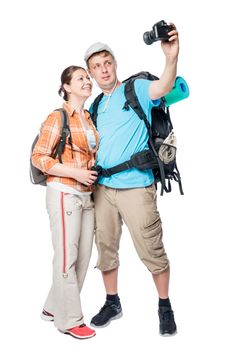 Young couple of extreme tourists doing selfie on camera on white background