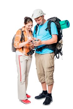 Couple of tourists looking at their photos on a camera on a white background