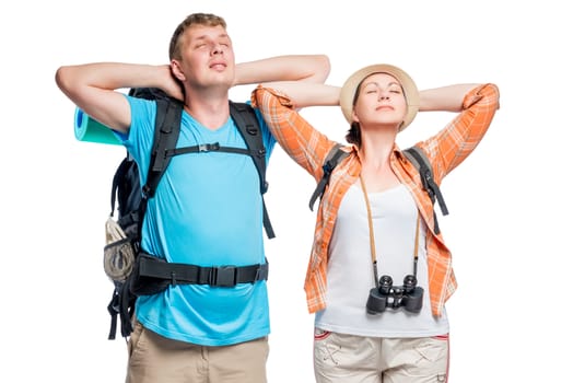 A resting couple of young tourists with backpacks on a white background