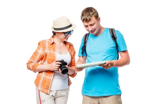 Girl photographer and male tourists looking at the map in the studio