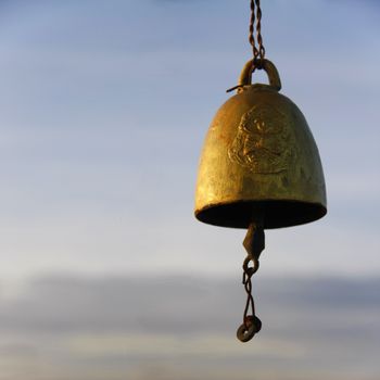 old golden bell hung in the air with reflex of sunshine on morning